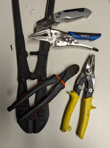 Five different cutting tools laid on a counter