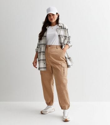 Image of a plus size woman dressed in plaid shirt and Joggers.