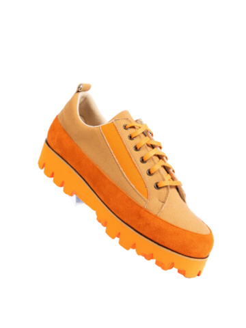 An orange and tan lace up lug sole sneaker