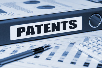 The word “PATENTS” on a dark blue folder.