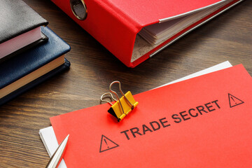 The words “Trade Secret” on a red folder.