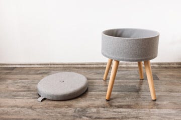 Trendy stool with and build-in storage. Side view, white wall, space