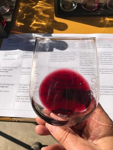 Photo of glass of red wine obscuring a restaurant’s menu.