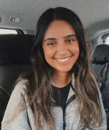 Image of a brown girl with black and brown hair in a powerchair.