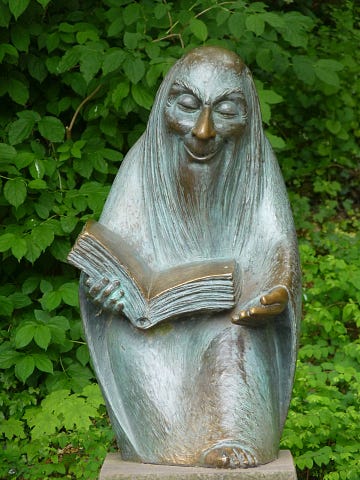 Garden statue of man reading a book