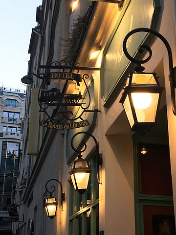 Hotel sign with lit pendant in yellowish mood, Paris