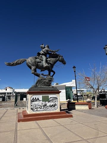 An equestrian statue of Pancho Villa at a gallup with a pistol drawn and his had falling from his head