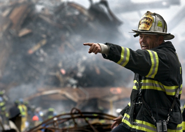 Stock photo of a firefighter incident commander pointing to something off camera at an emergency site.