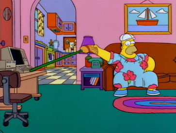 Homer Simpson watching TV while using a broomstick to hit his keyboard across the room.