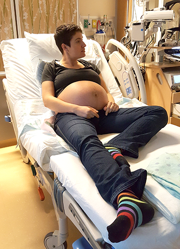 Dr. Juno Obedin-Maliver sitting on a hospital bed during one of her check-ups during her pregnancy.