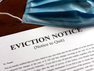 A blue mask rests on top of an eviction notice