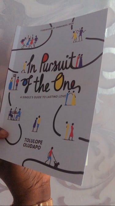 A picture of me holding a book titled “In Pursuit Of The One” by Tolulope Oludapo.