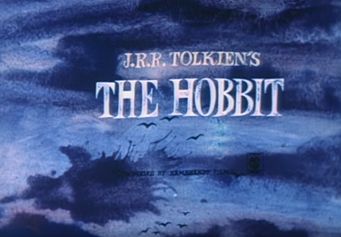 A still from an adaptation of The Hobbit showing bluish clouds and birds with the text “J.R.R. Tolkien’s The Hobbit” in all caps.