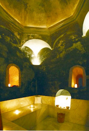 a dimly light stone bathing room at a spa