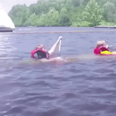 Two kids with a row in a kayak that is sinking in the river.