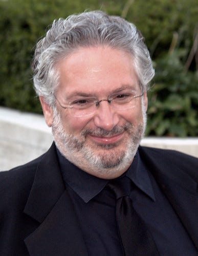 A photograph of actor Harvey Fierstein. He is smiling, wearing glasses and has grey hair and a grey beard.