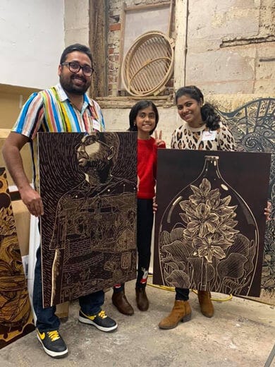 Melvin, Nimmy and their daughter showing the wood cuts at Big Ink.