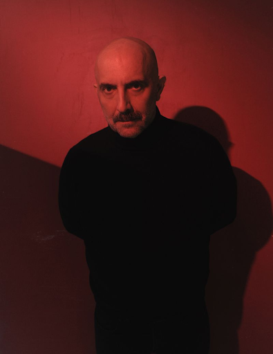 Portrait image of director Gaspar Noe with sinister red lighting
