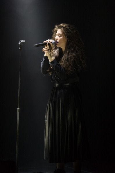 The New Zealand singer Lorde on stage singing in a long black dress