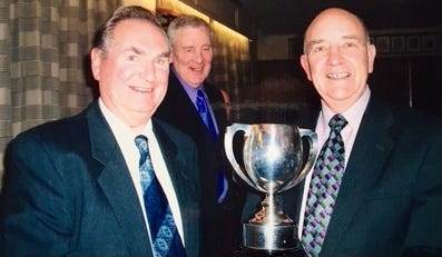 Bryan receiving the cup from the president Mike Jones, with captain Gordon Shoemark