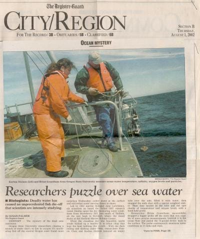 A newspaper clipping showing two researchers on a boat at sea wearing life vests.