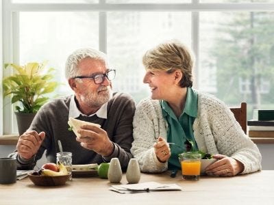 Senior couple enjoying a staycation having breakfast at home.
