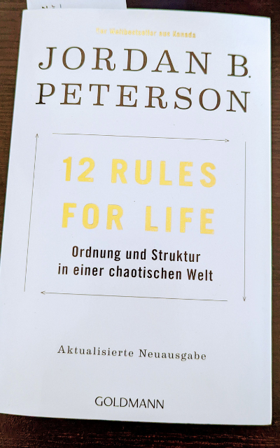 Ein weißes Cover mit einem Goldenen Schriftzug. 12 Rules For Life. Darunter steht in kleinerer schwarzer Schrift: Ordnung und Struktur in einer chaotischen Welt