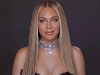 Fotografia da cantora Beyoncé. A cantora está com o cabelo loiro repartido ao meio e um colar de pedras prateado.