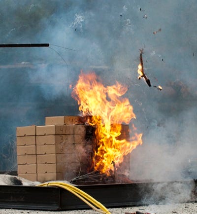 A pallet of boxes on fire.