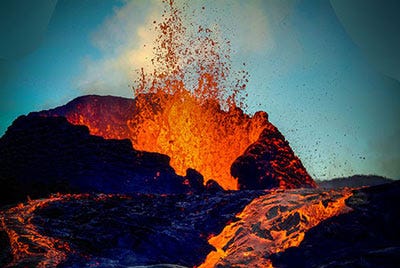 A night photo of an erupting volcano.