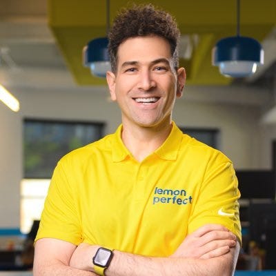 A headshot of Yanni Hufnagel in a yellow shirt that says “Lemon Perfect”