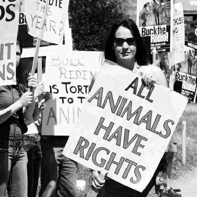 Animal rights activists and an activist woman holding a sign ‘All animals have rights’