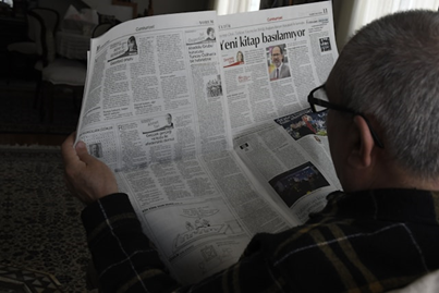 Image of a person reading a newspaper to illustrate post