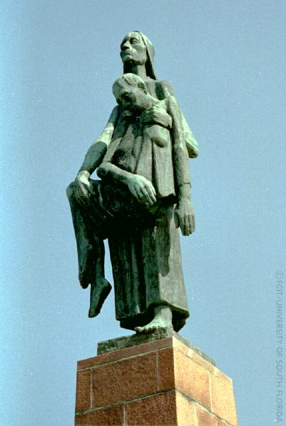 Escultura de Will Lammert, “Carrying Woman, inspirada em Olga Benário. Em que aparece uma figura feminina segurando pelos braços um pessoa sem vida, enquanto seus olhares estão para cima.