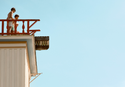 Two people overlooking blue skies from a tower