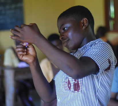 A girl in Ghana looking at a menstrual cup