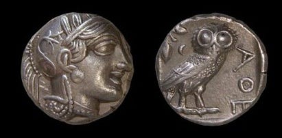 Athens silver drachma with Athena’s face on one side and owl holding olive branch on back.