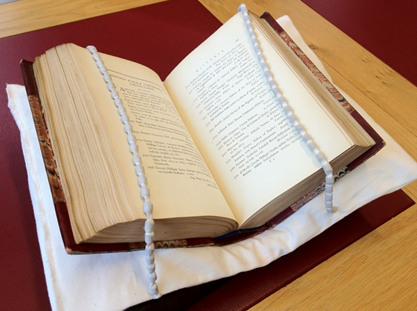 Two snake weights hold down an open book in the Reading Room.
