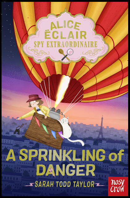 Large book cover. Alice Eclair leans over the edge of the hot air balloon basket, pointing to Paris below. The sky is filled with stars, and there is a blue, purple and light umber horizon picking out the buildings and eiffel tower below. Casper, the white cat, hangs on for dear to the outside of the basket. The balloon is of verticle stripes alternating in red and yellow. The basket has multicoloured bunting on the outside. ‘Alice Eclair Spy Extraordinaire’, appears in an ornate cake-pink pane