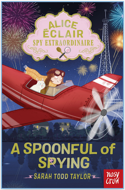 Alice sits in a red monoplane with an open cockpit, with Casper the cat beside her. They dive through the skies over Paris, fireworks going off behind in the sky. Alice’s yellow scarf is streaming behind her.