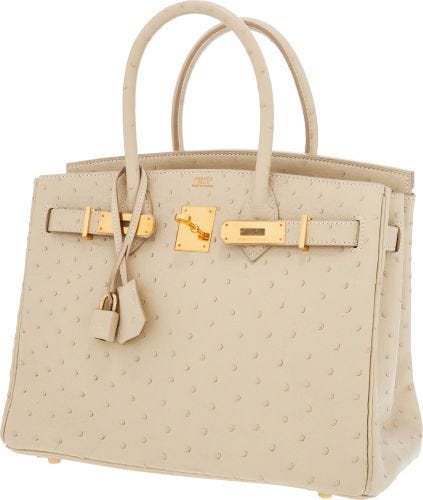 A cream colored Birkin bag made from ostrich skin.