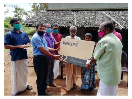 A TV for watching video lessons is given to the parents of a needy student
