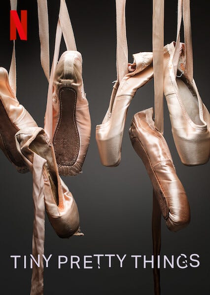 3 pairs of pointe shoes dangling by their ribbons