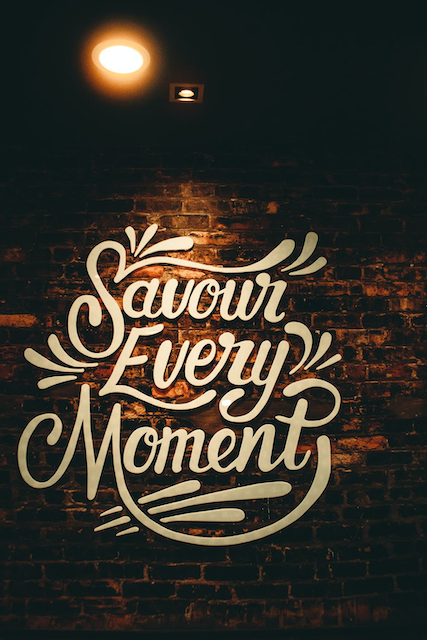 A cursive text that reads “Savour every Moment”
