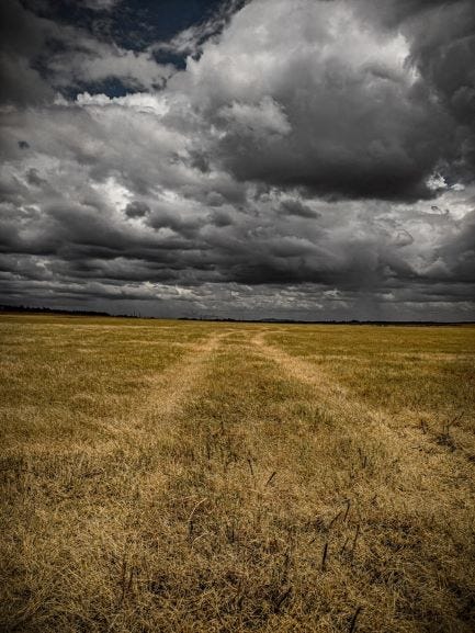 barely visible path with storm clouds amidst a dark sky