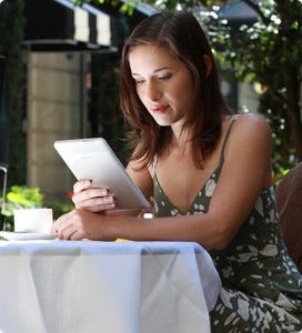 A woman reading a tablet as a representation of the number of women who are self publishing and having their books available on ereaders.