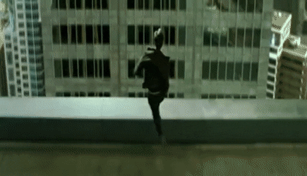 GIF of a scene from The Matrix where Neo attempts to jump across the gap between two roof tops, but falls down to the street below on his face.