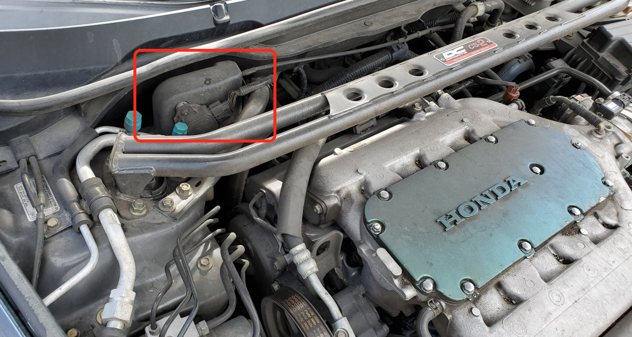 View of engine bay with sensor cover circled in red