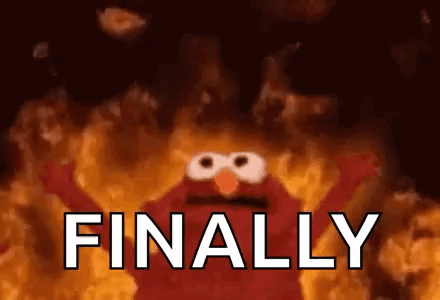 A animated gif of a muppet with fire behind it. The muppet has arms in the air with the text “Finally”