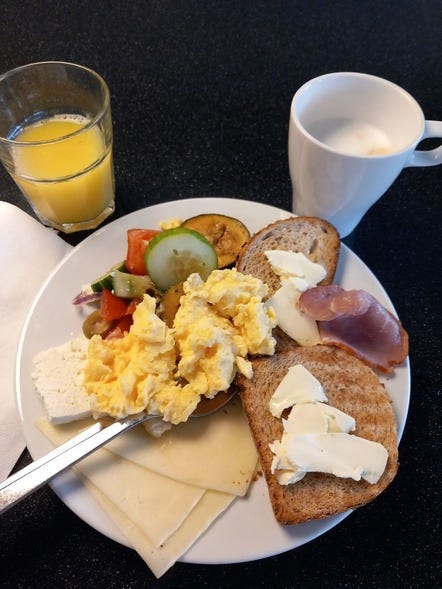 a plate of food with eggs, hams, and toast